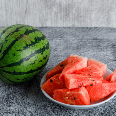 watermelon-with-slices-grey-grunge-table